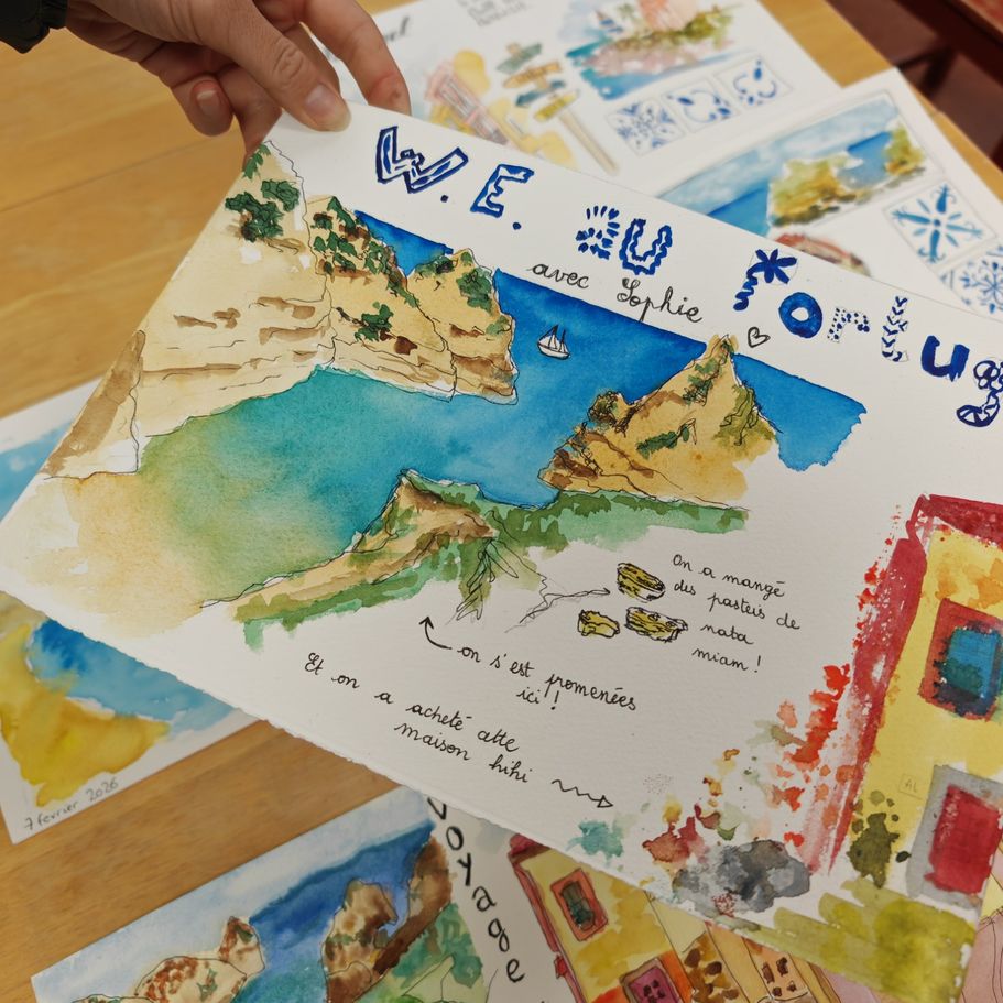 Atelier carnet de voyage en extérieur : moi expliquant une technique d’aquarelle à une élève dans un parc